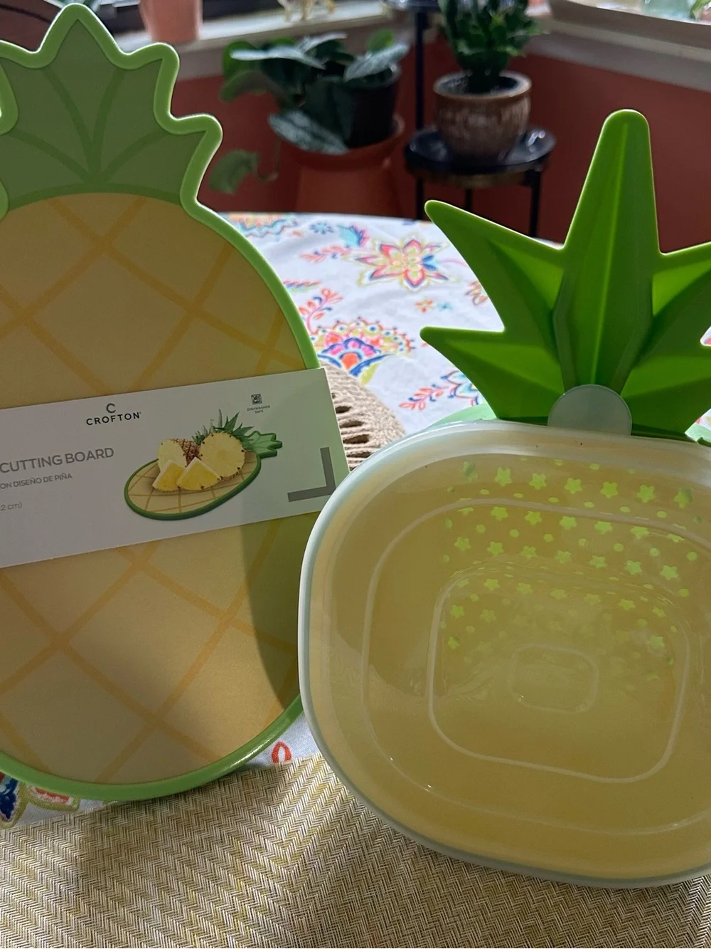 Croton Pineapple-Shaped Cutting Board in Yellow with Green Trim and Colander.